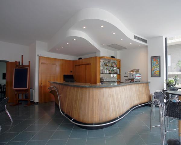 Moderne Bar mit Holztresen und Metallstühlen.